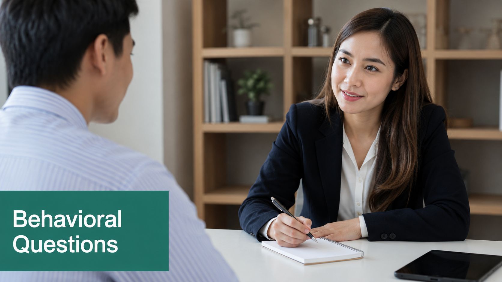 A professional recruiter conducting a job interview with a candidate in a bright, modern office setting.