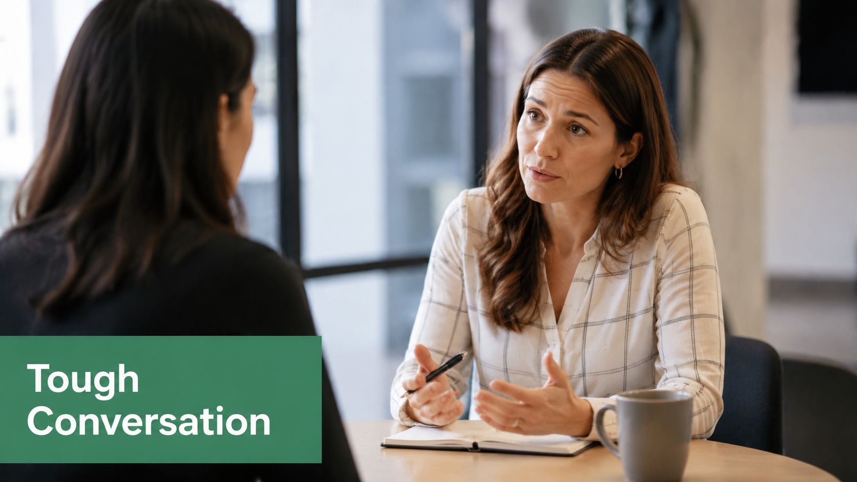 A professional woman having a serious discussion with her colleague during an office meeting at a desk.